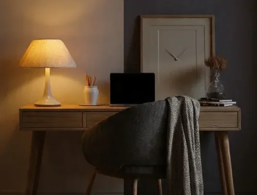 Minimal workspace with a closed laptop, a small plant, and soft warm light, symbolising healthy work–life balance and boundaries.